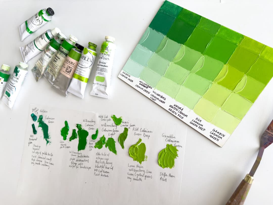 About 9 tubes of paint which include some cadmium greens set next to some permanent greens so a person can make comparisons.