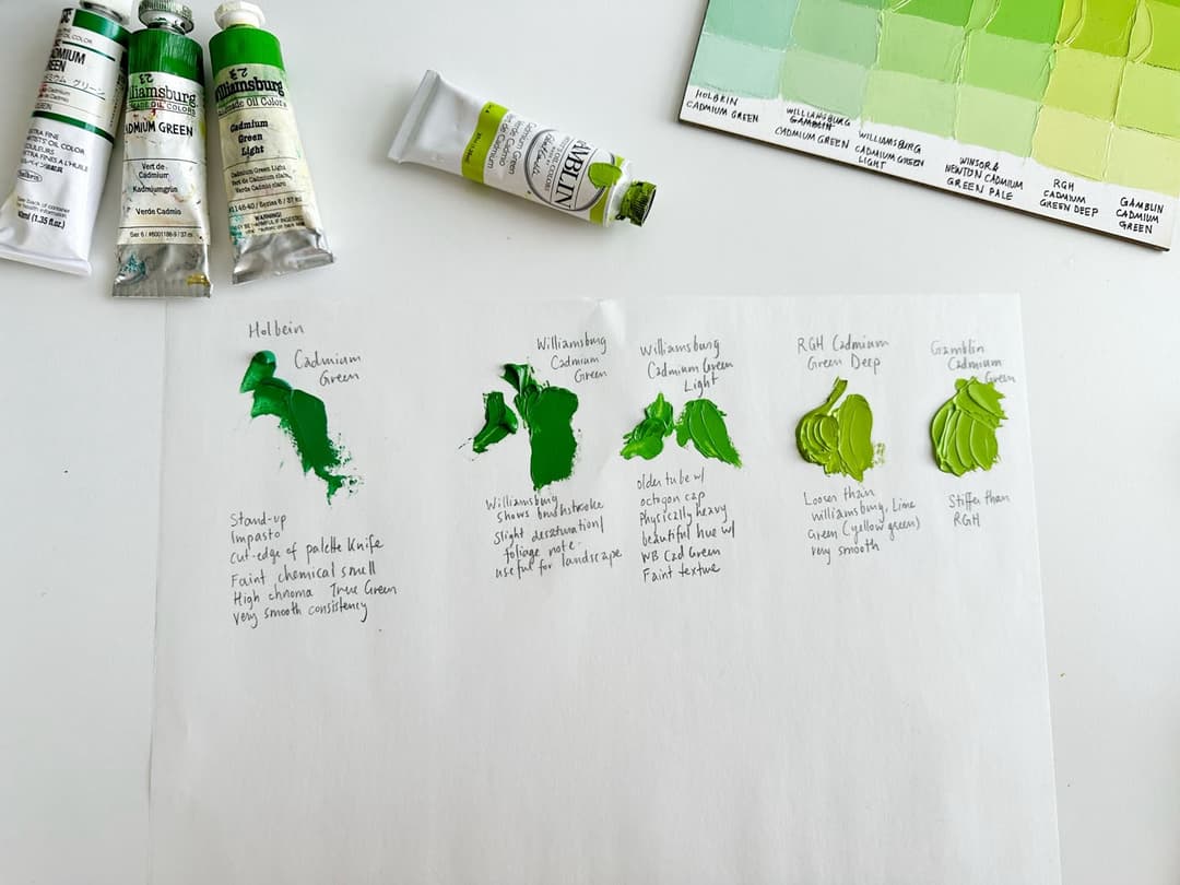 Four tubes of paint with a paper where the colors are sampled. Some of the piles of paint have defined ridges made with a palette knife.