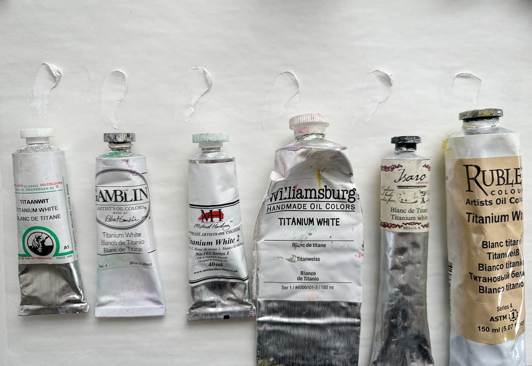 Six tubes of Titanium White oil paint showing that all the paints are similarly white out of the tube.